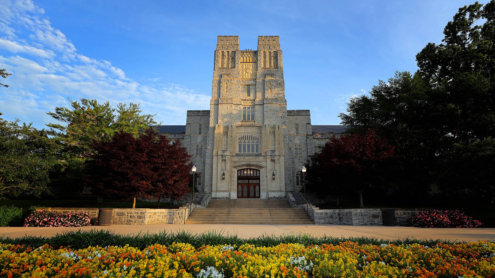 Exterior photo of Burruss Hall with flowers blooming in the foreground